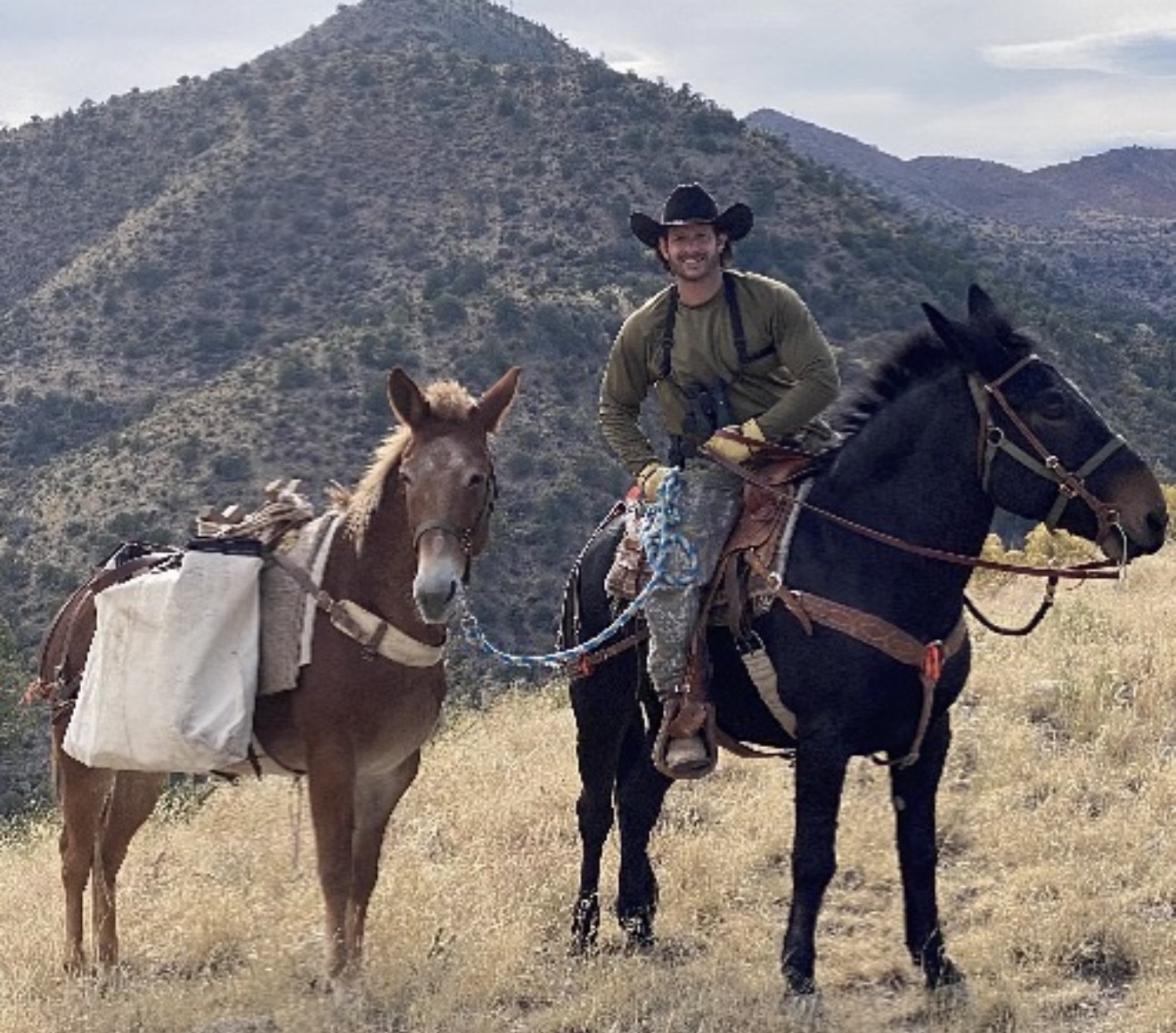 Christopher on horseback in a rugged mountain landscape